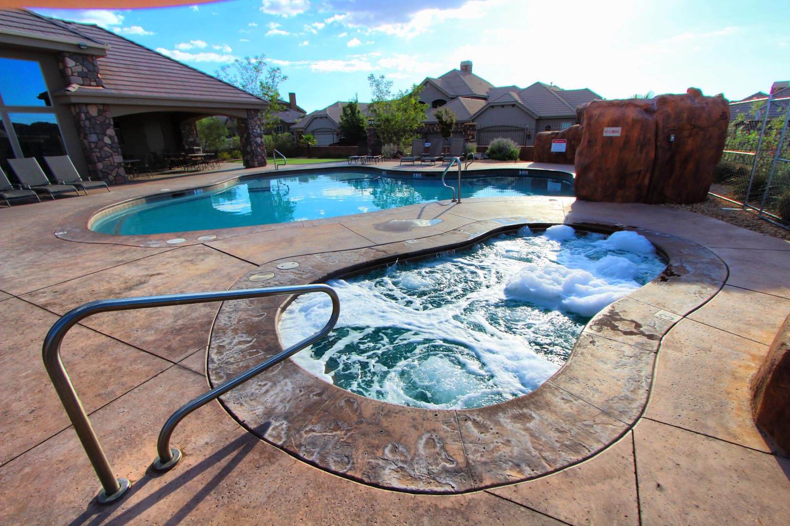A crisp outdoor swimming pool and Jacuzzi at VRI's Canyon Villas at Coral Ridge in Washington, Utah.